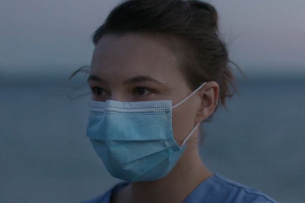 Close up of a healthcare worker's face with a disposable face mask on.