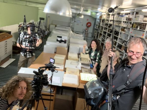 Photo of film crew and two presenters in the archive room.